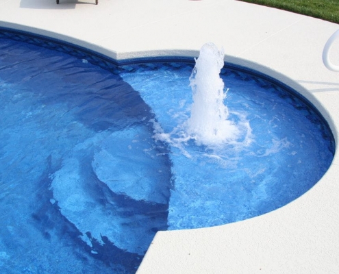 a wading area in a pool with a fountain