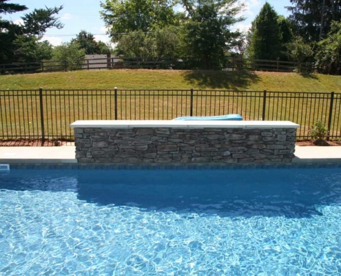 a wall next to an in-ground pool